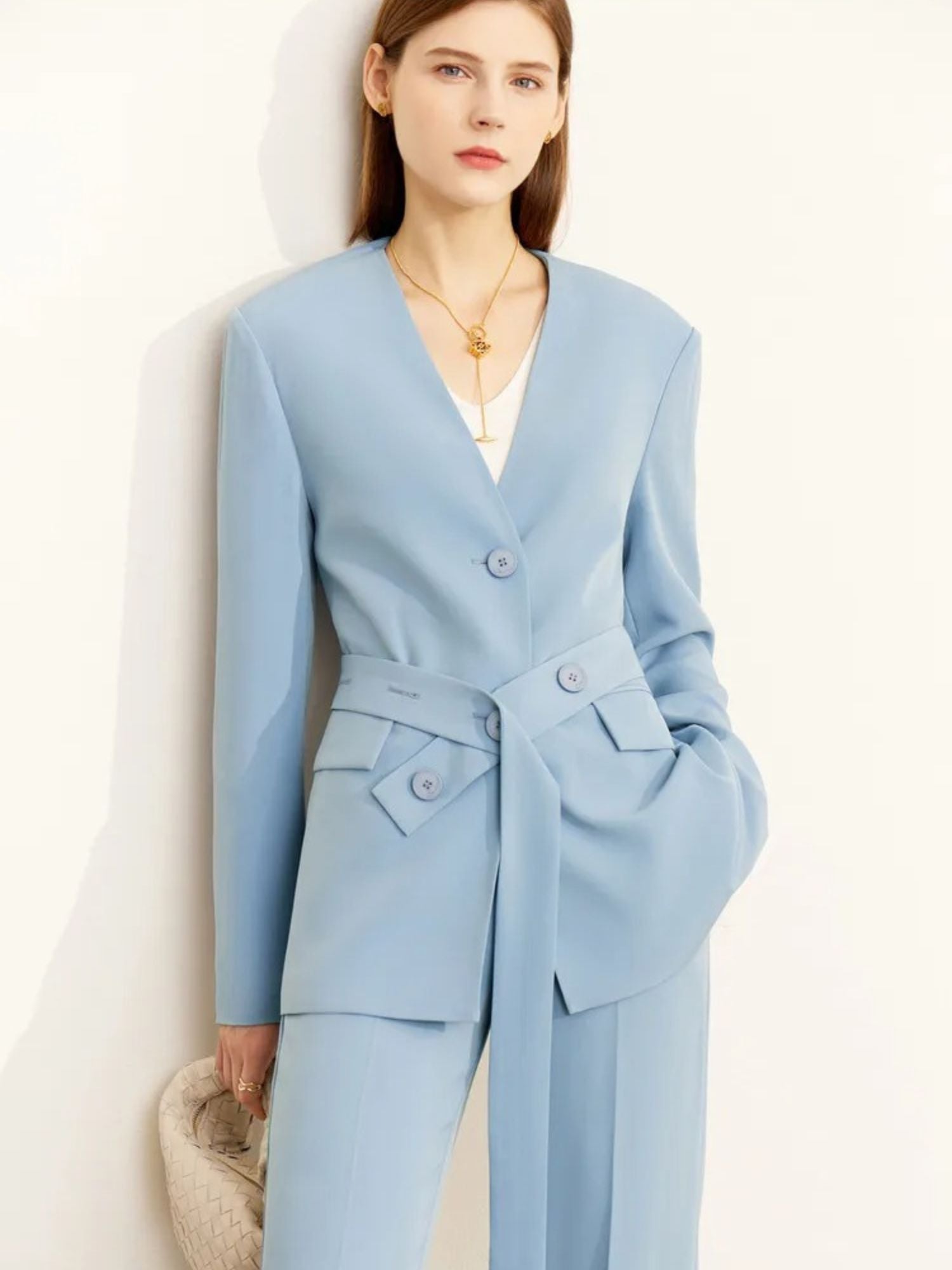 Woman wearing a light blue suit against a white background