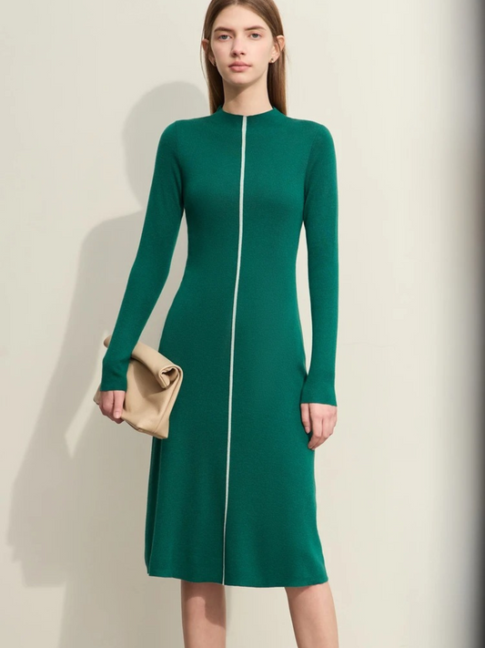 Women's green long-sleeve midi dress with front zipper, fitted silhouette, and crew neckline. Model holding a beige clutch