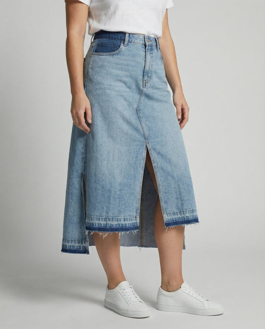 Person wearing a blue denim skirt with a white background