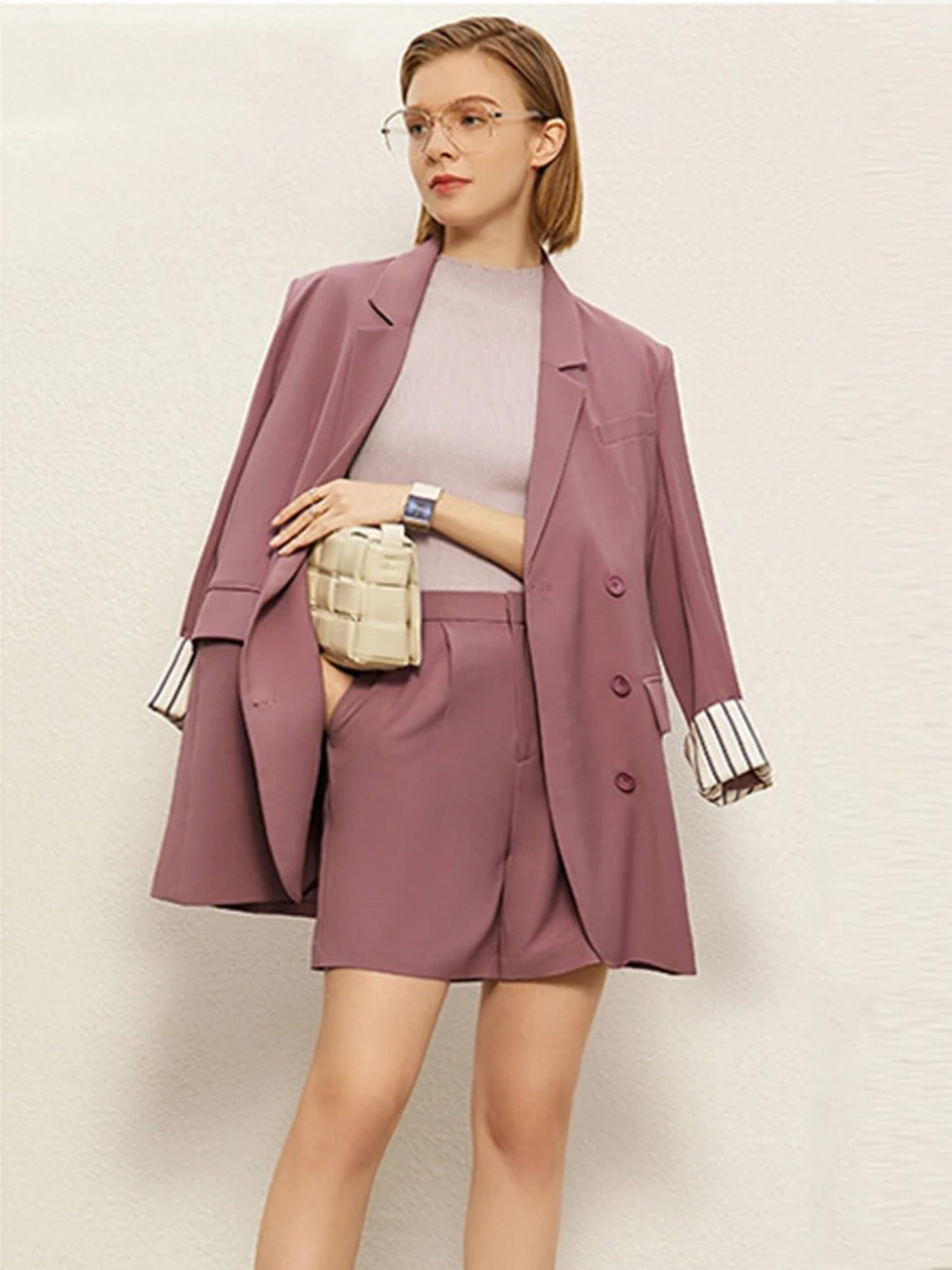 Woman wearing a mauve suit with a plain background