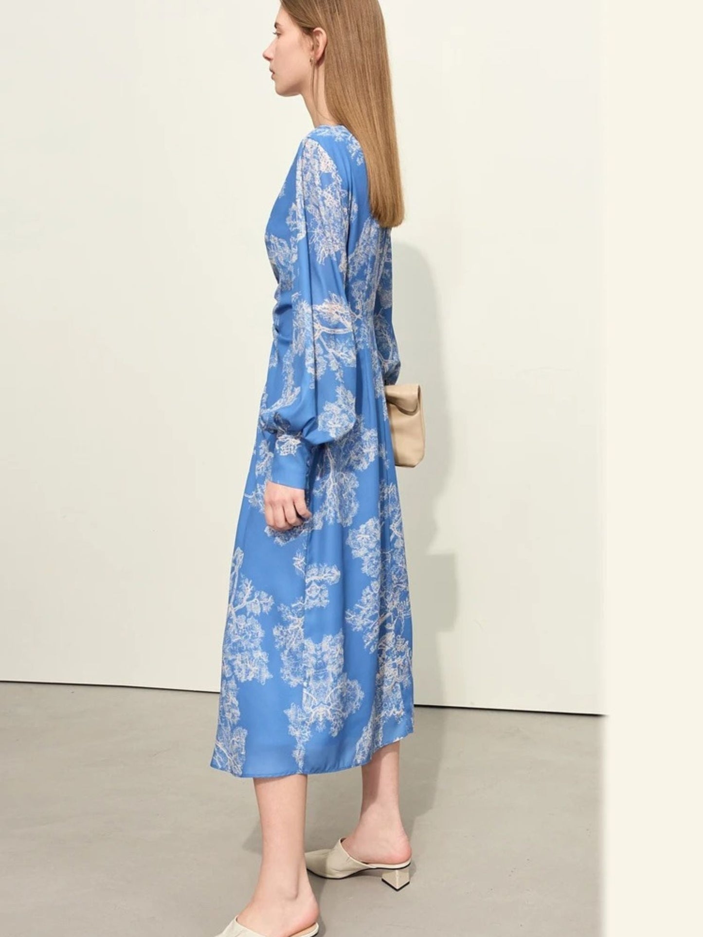 Side view of blue floral wrap midi dress with ruched front and long puff sleeves