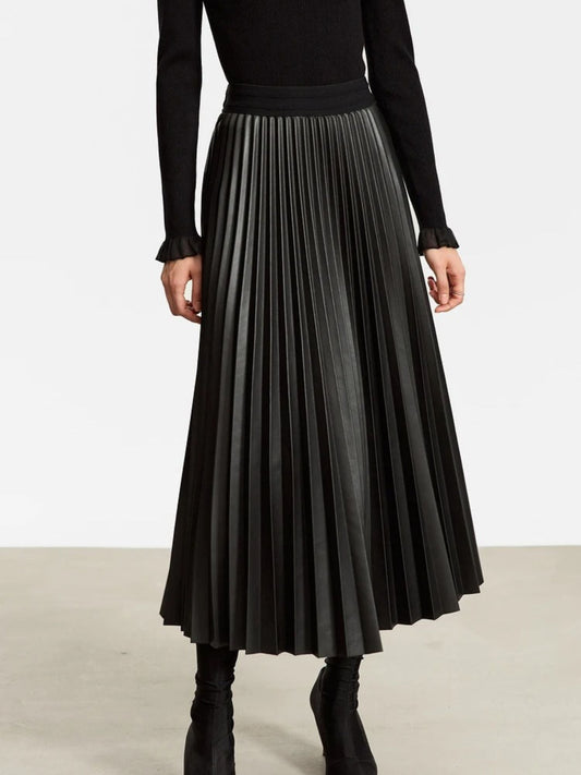 Women's black faux leather pleated midi skirt with high waist, styled with black long-sleeve top and black boots