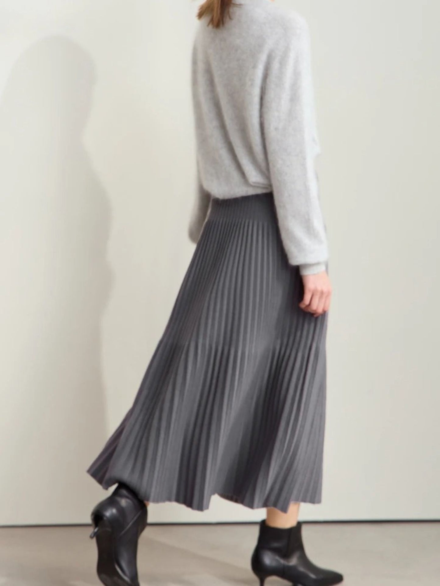 Back side view of gray pleated midi skirt with color-block detail
