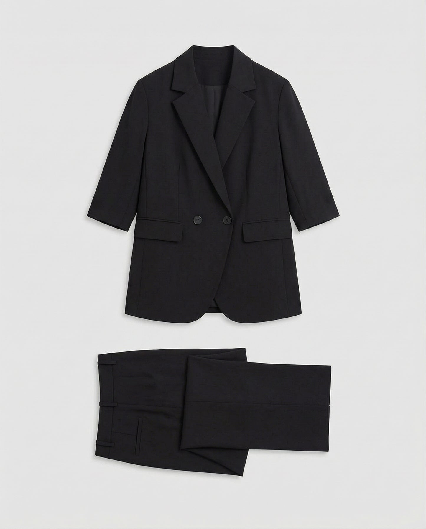 Black suit jacket and pants on a light gray background