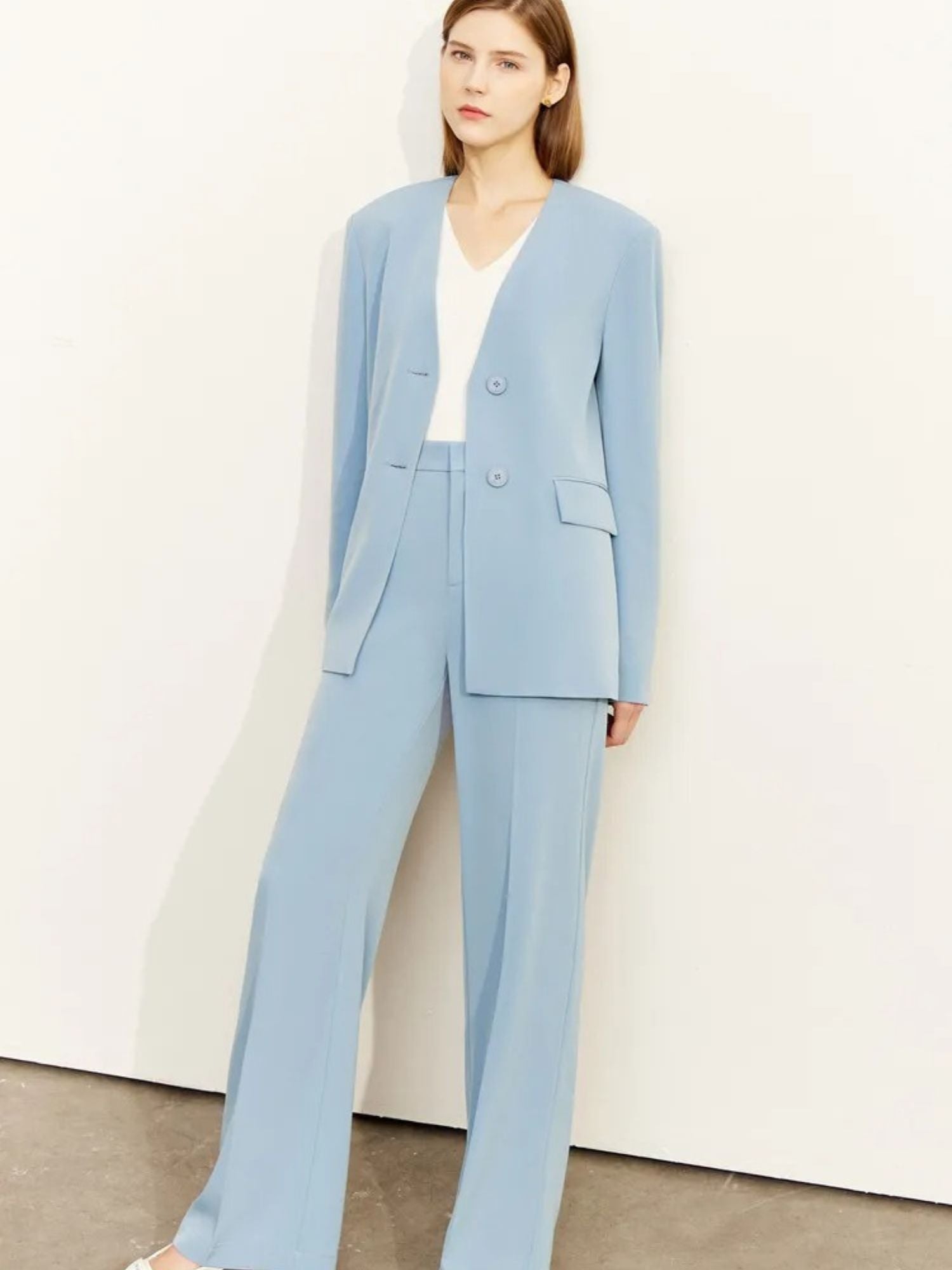 Woman wearing a light blue suit against a white background