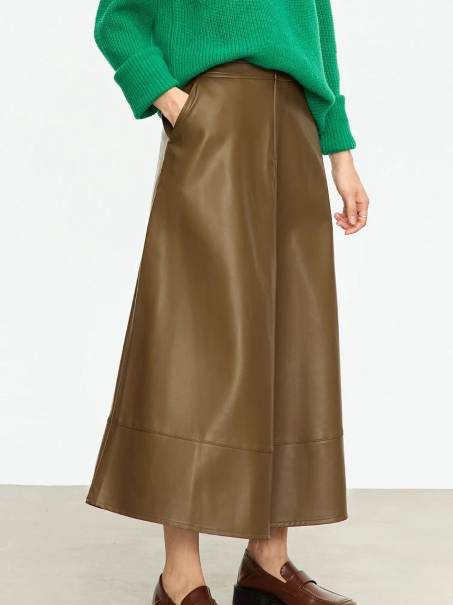 Flat lay of black and brown faux leather midi skirts with A-line silhouette