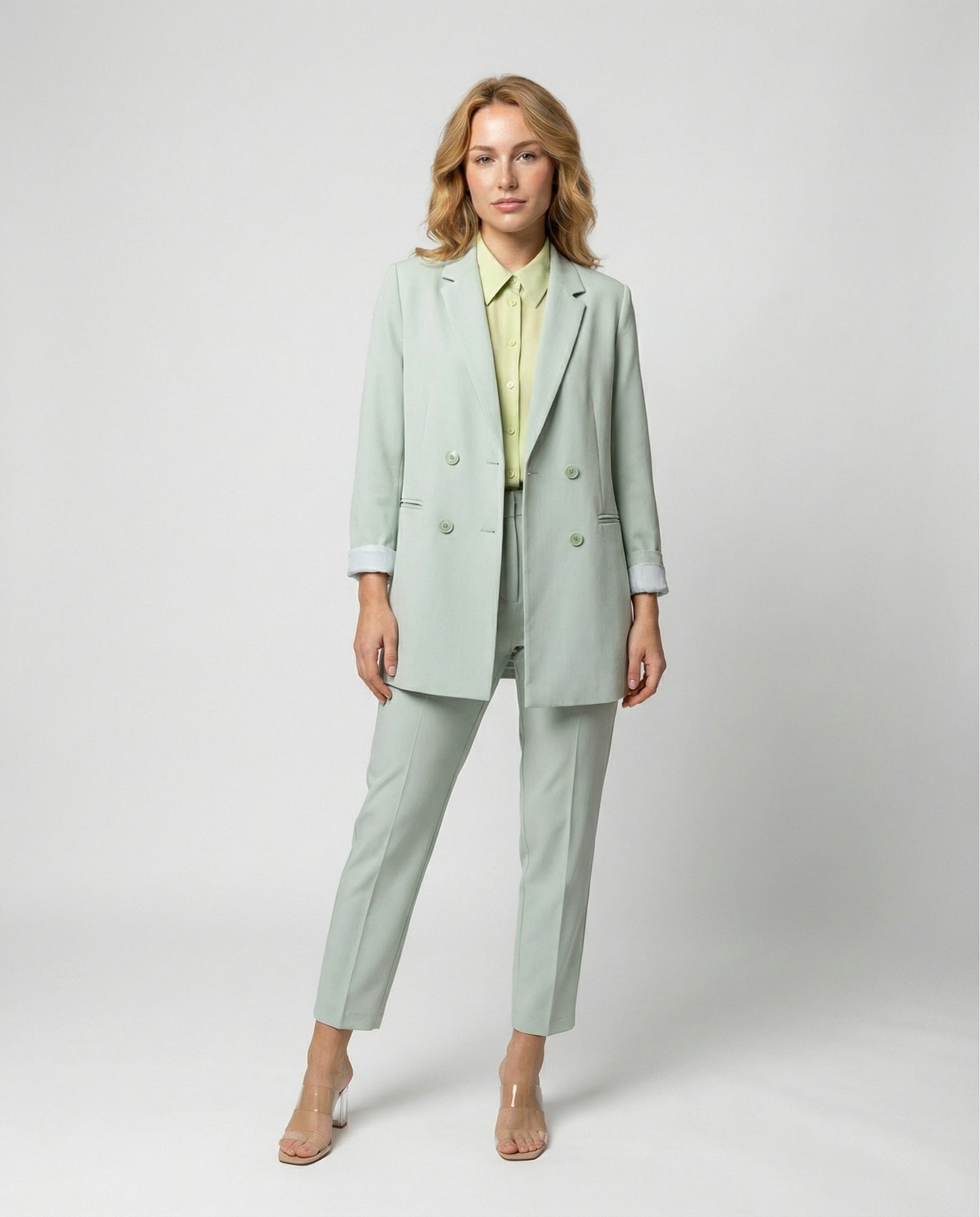 Woman wearing a light green suit with a white background