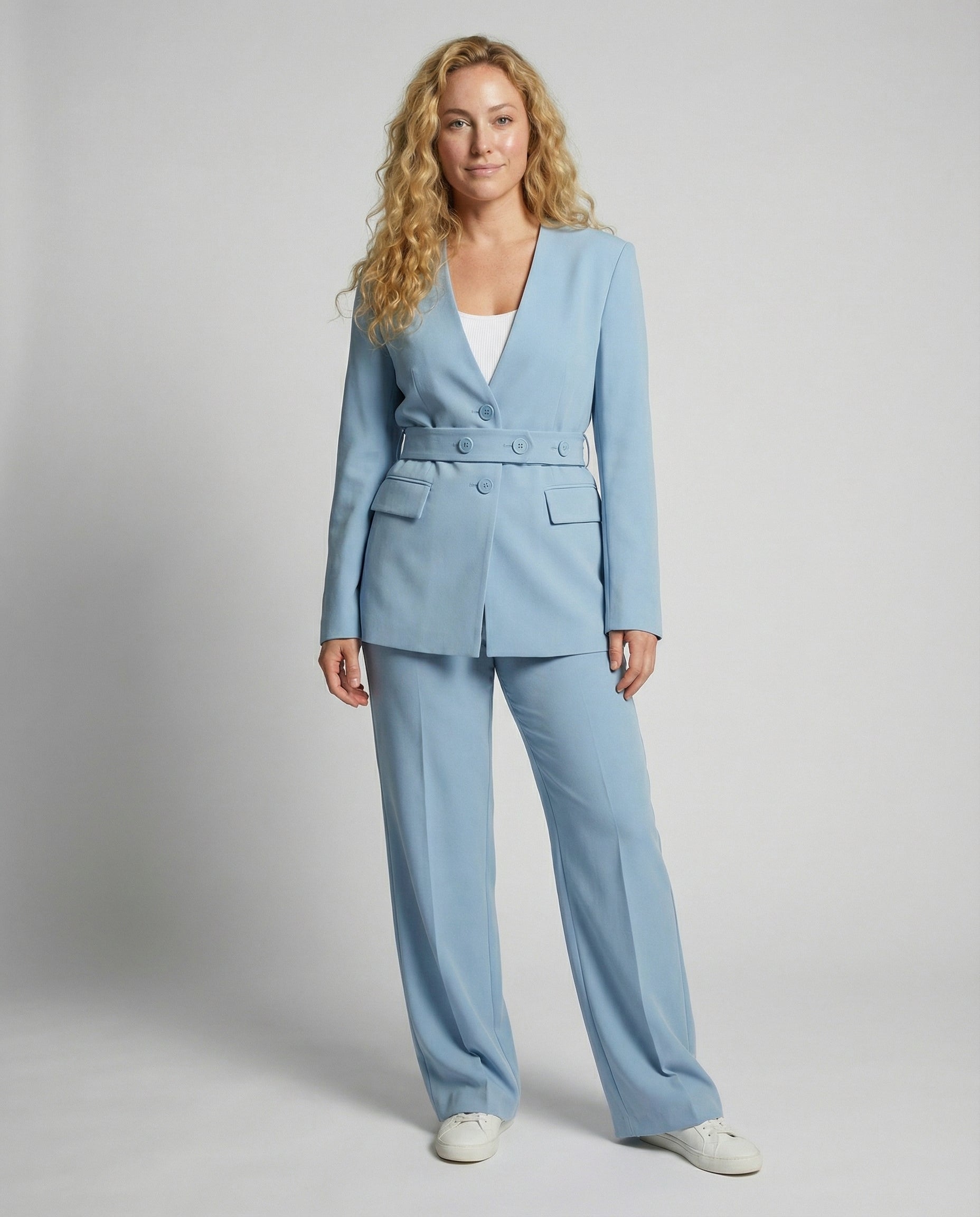 Woman wearing a light blue suit against a plain background