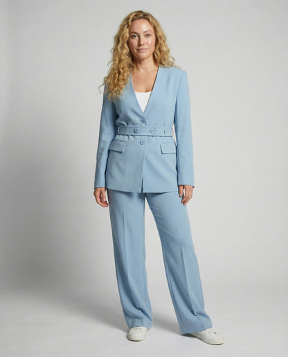 Woman wearing a light blue suit against a plain background