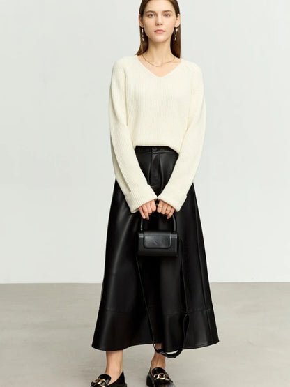 Black faux leather midi skirt styled with white sweater and black handbag