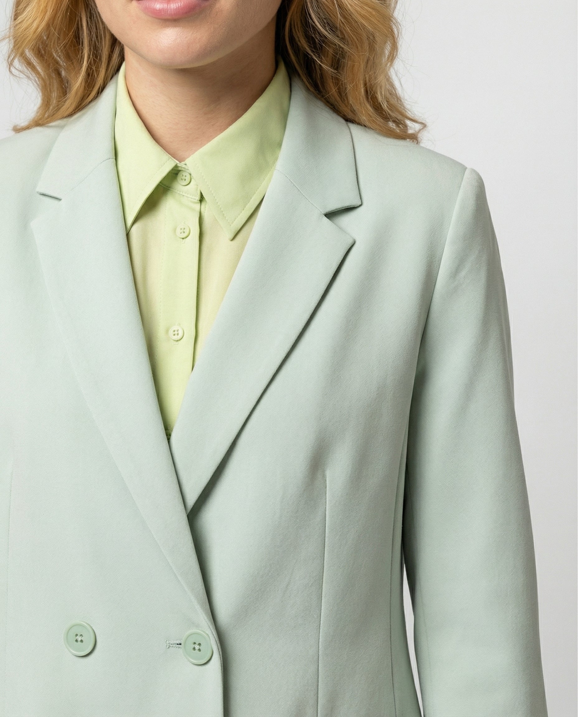 Light green blazer worn by a person on a plain background
