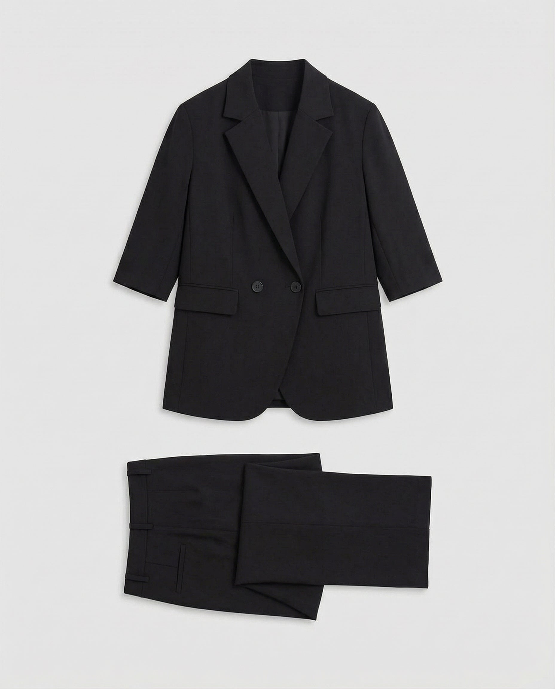 Black suit jacket and pants on a light gray background