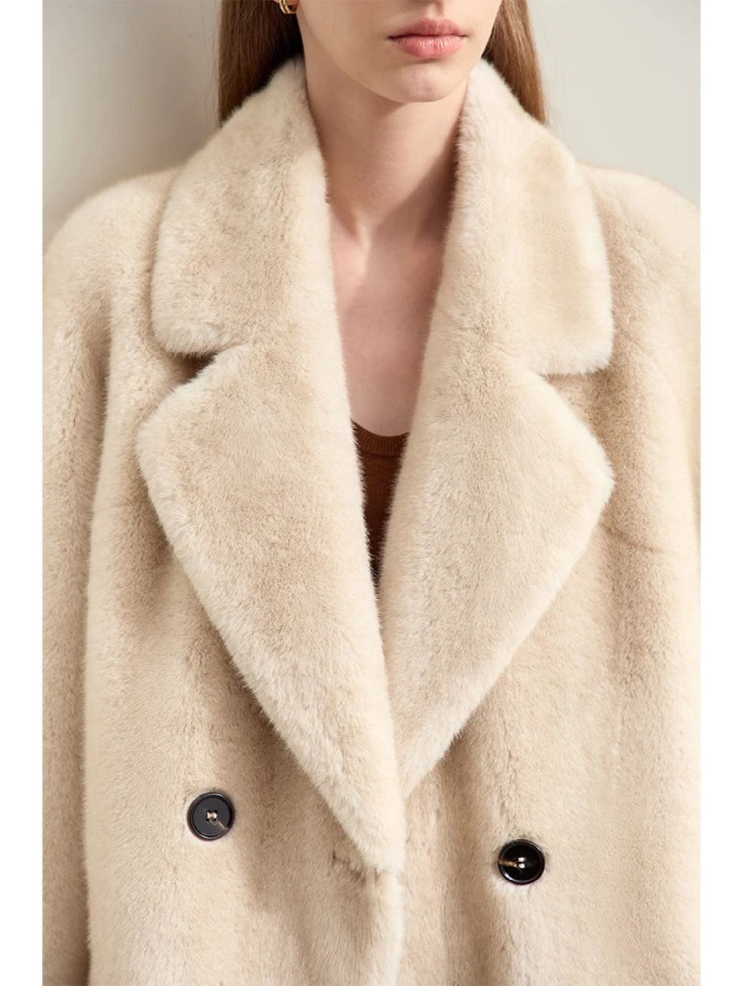 Close-up frontal crop of the coat showing the collar, lapels, and top part of the double-breasted button detail. The texture of the fabric appears soft and slightly fuzzy