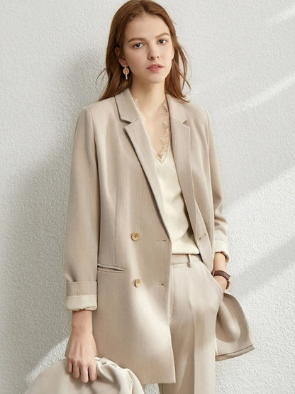 Woman in a beige oversized blazer and matching trousers, paired with a pale blouse and a taupe crossbody bag