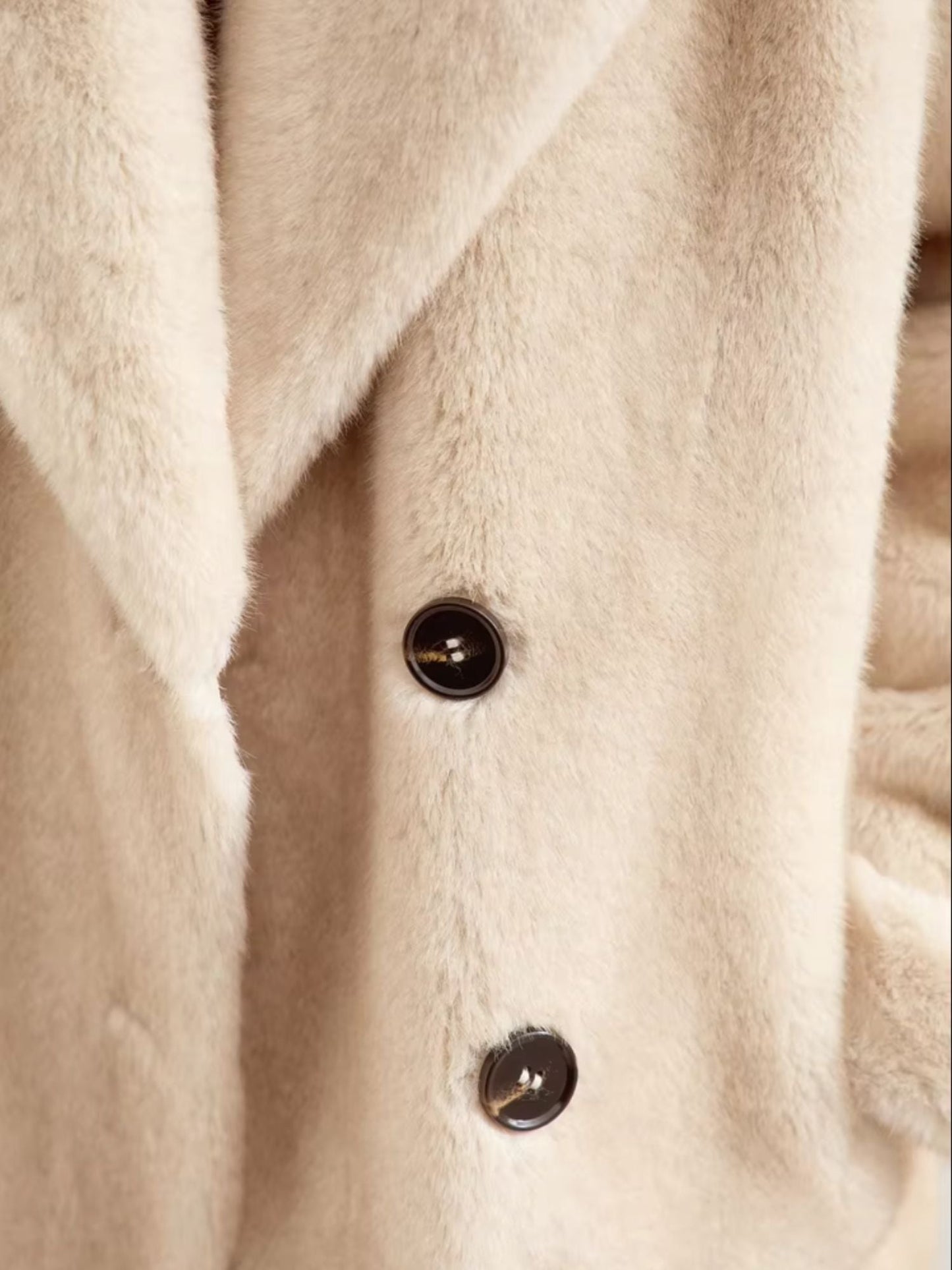 Another close-up, this time showing the lapel and button area in more detail. The stitching and craftsmanship of the coat are visible