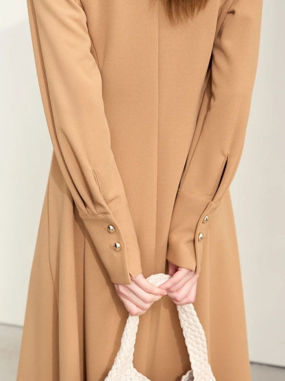 Close-up of camel midi dress sleeve showing gold button details