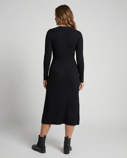 Woman wearing a black ribbed dress with long sleeves on a white background