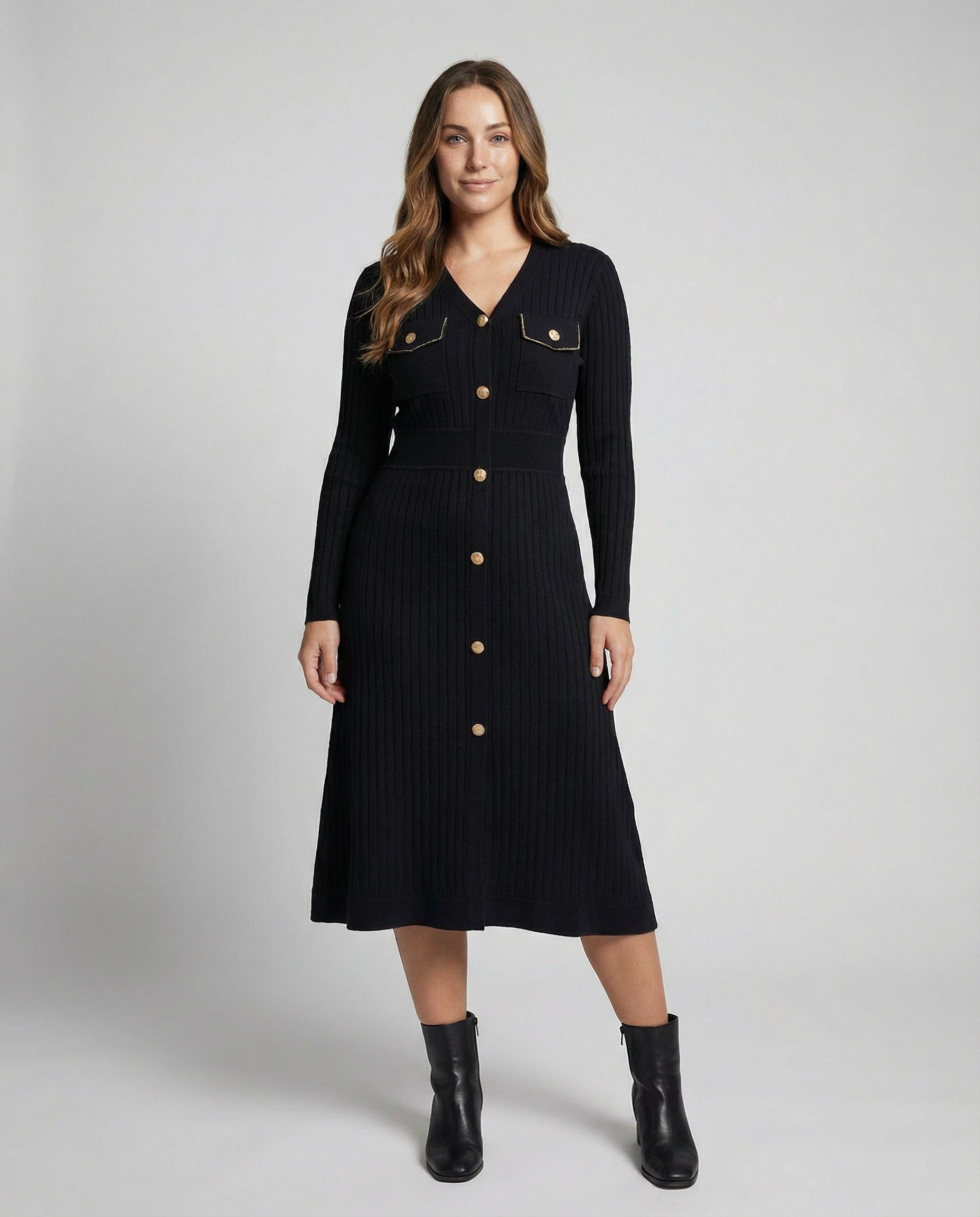 Woman wearing a black dress with buttons on a white background