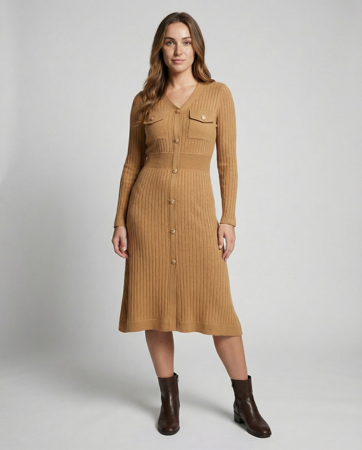 Woman wearing a brown ribbed dress with long sleeves on a white background