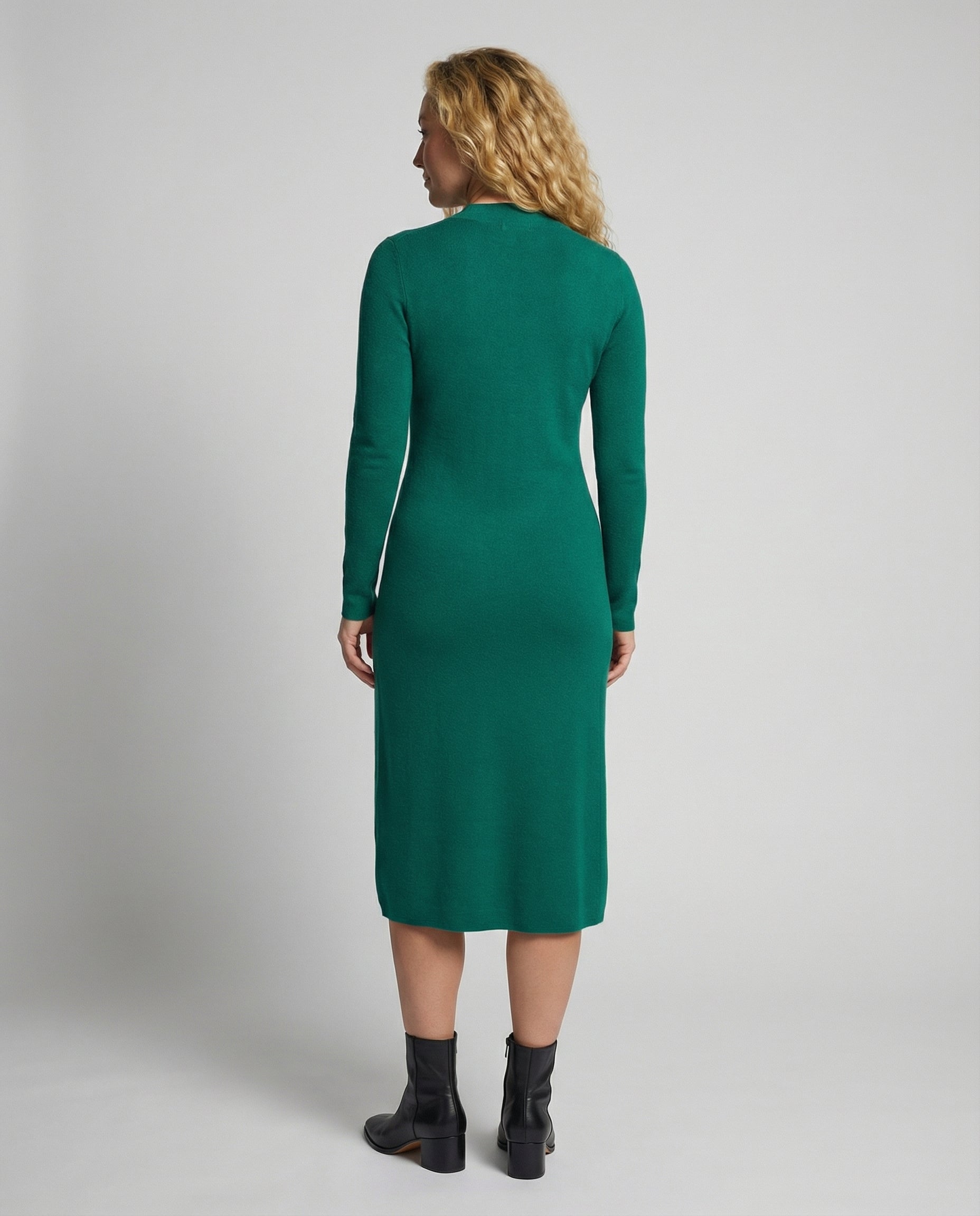 Woman wearing a green dress from behind on a plain background