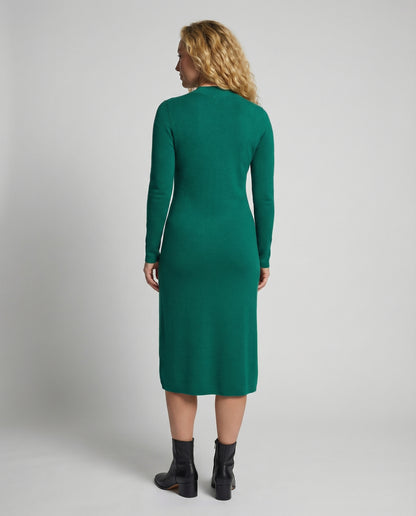 Woman wearing a green dress from behind on a plain background