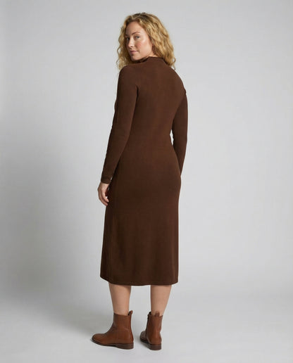 Woman wearing a brown dress against a plain background