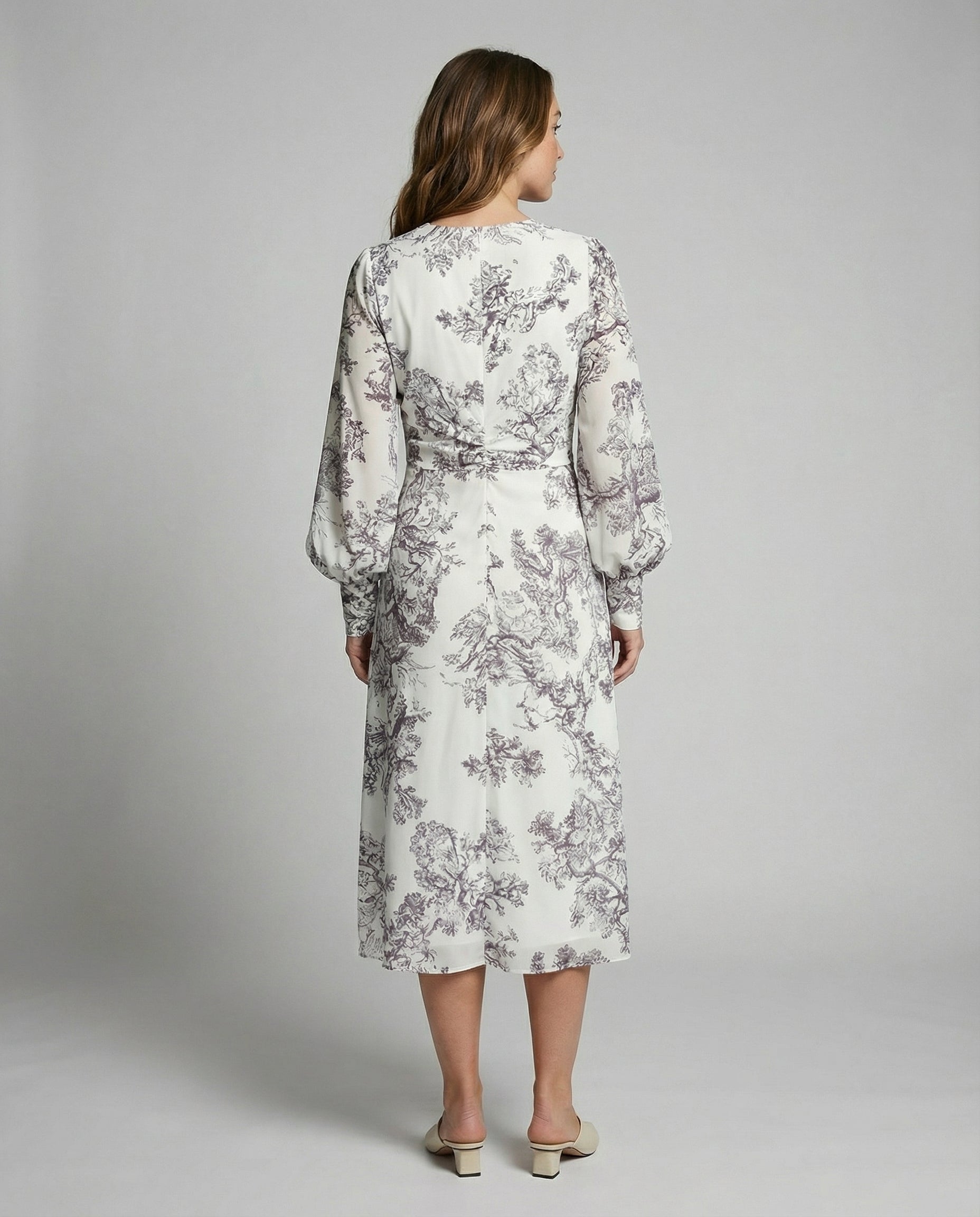 Woman wearing a floral dress on a plain background