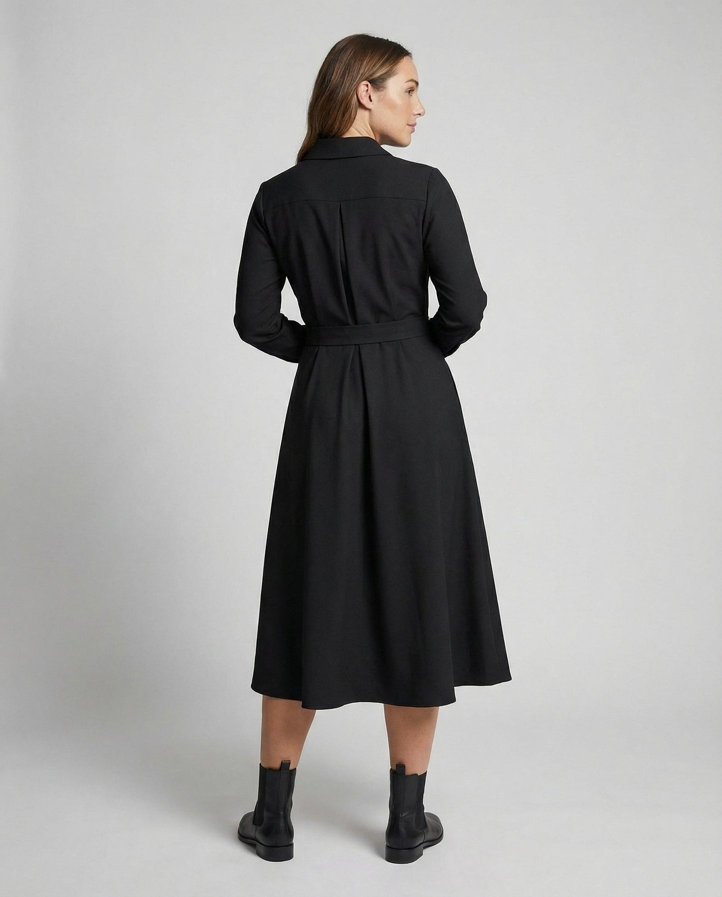 Woman wearing a black coat on a plain background