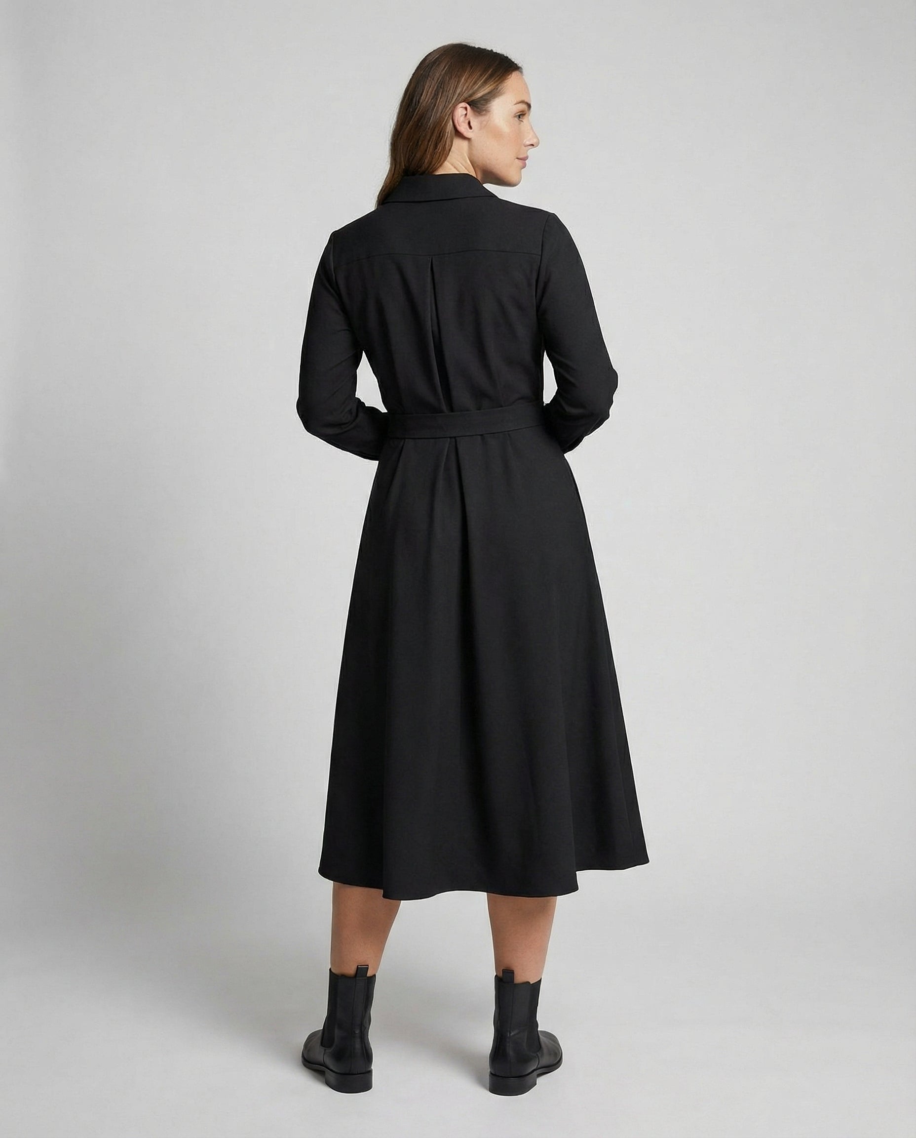 Woman wearing a black coat on a plain background