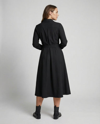 Woman wearing a black coat on a plain background