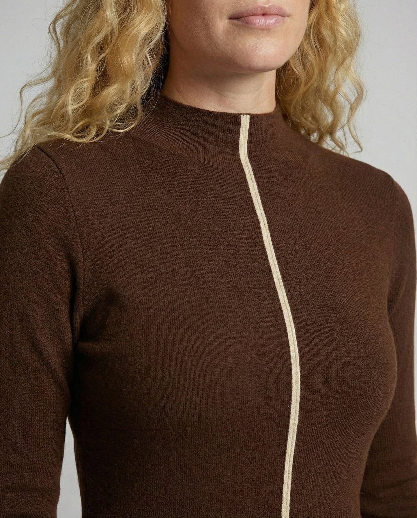 Brown long-sleeve top with a white zipper detail on a neutral background
