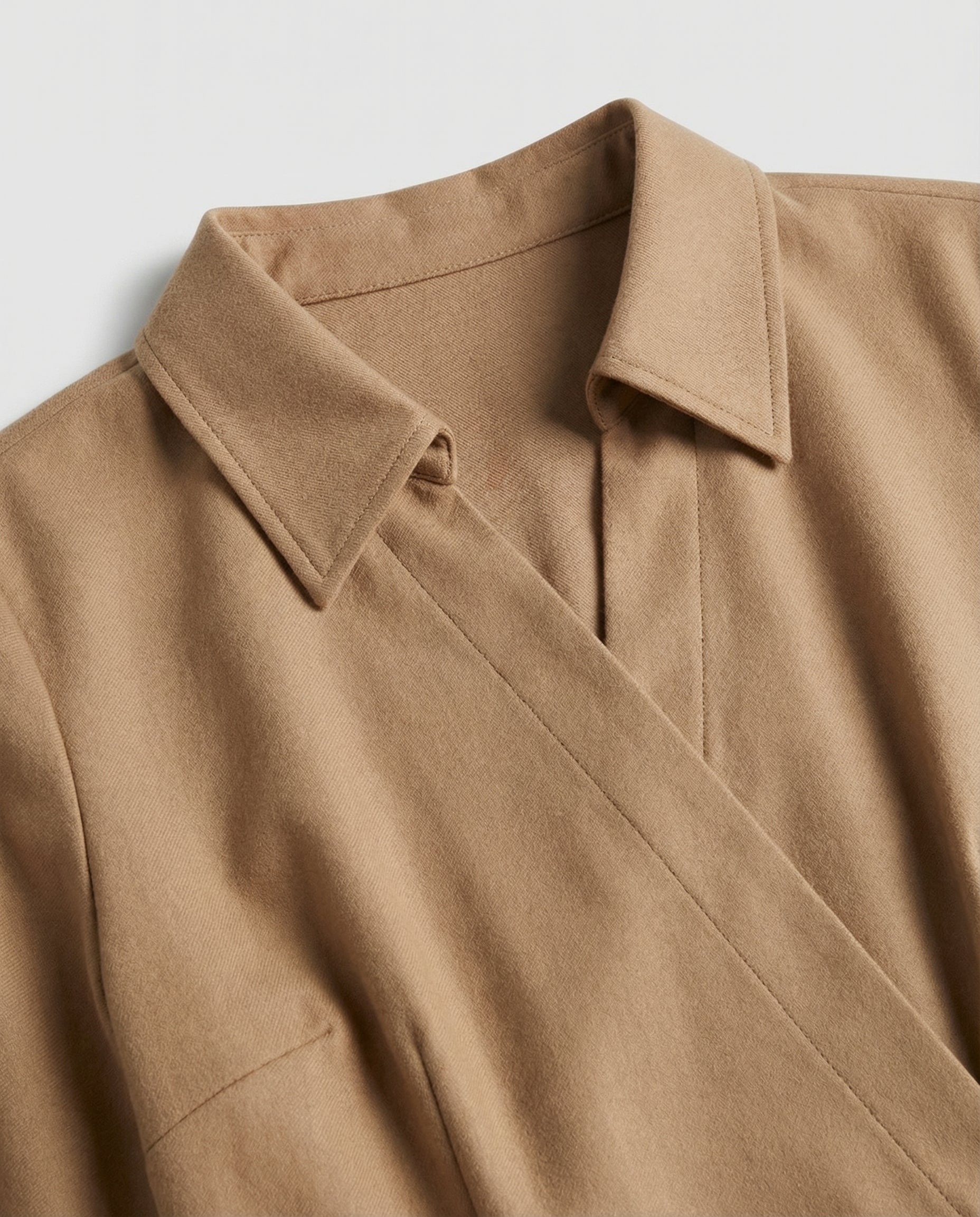 Close-up of a brown coat with a collar on a light gray background