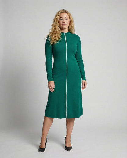 Woman wearing a green dress with a white zipper on a gray background