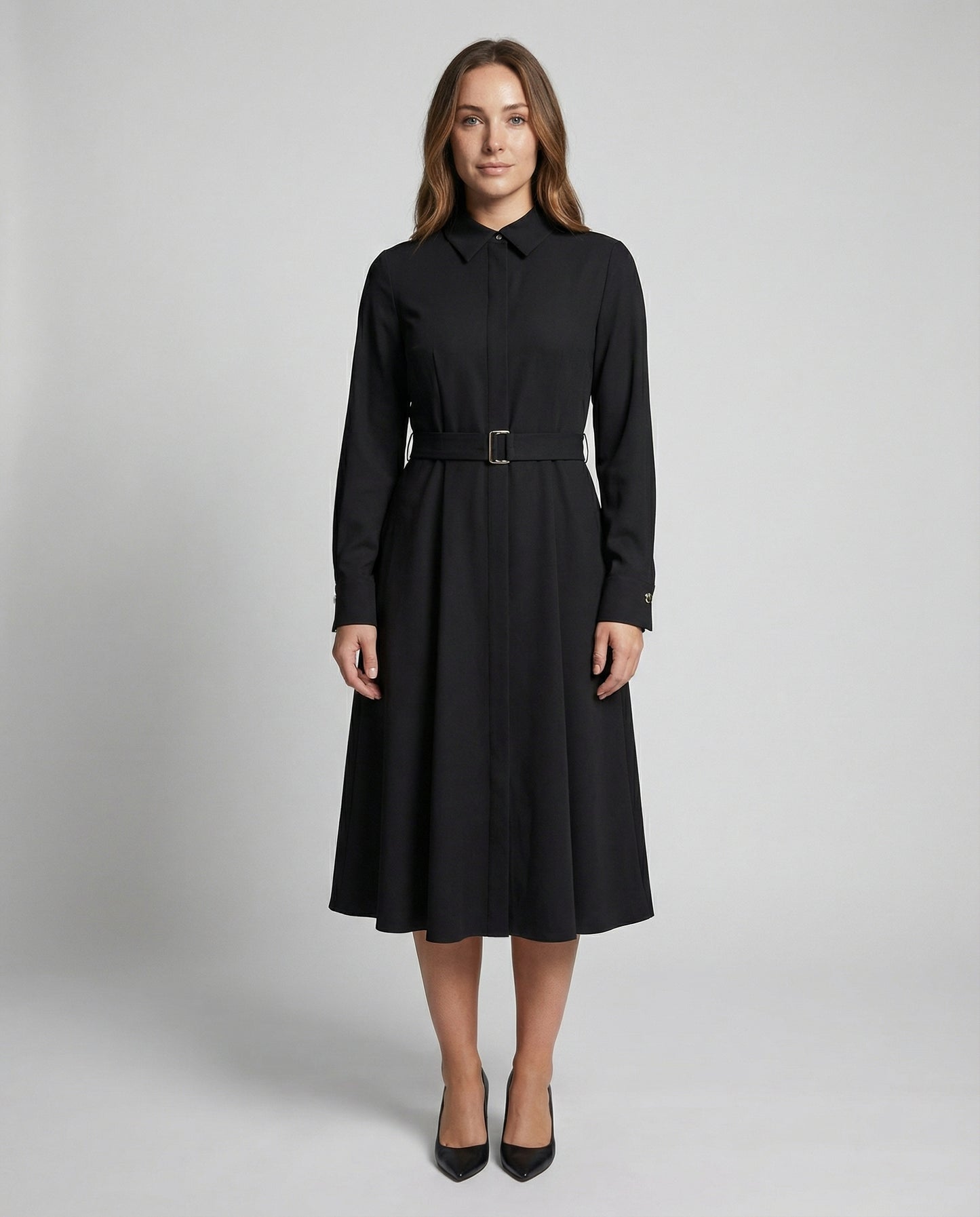 Woman wearing a black dress with a belt on a gray background