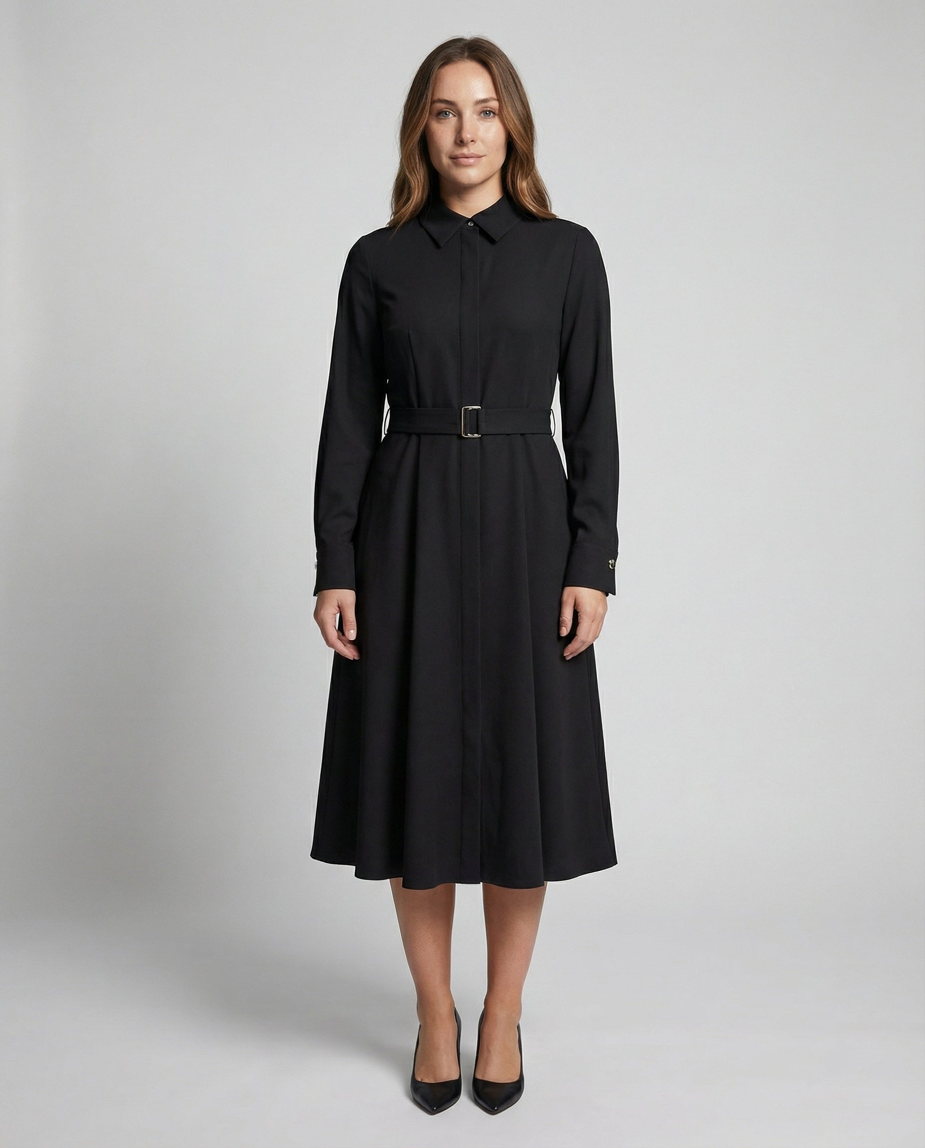 Woman wearing a black dress with a belt on a gray background